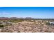 Wide aerial shot of a community featuring desert landscape, water features, and mountain views under a clear sky at 7931 W Harmony Ln, Peoria, AZ 85382