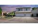Charming two-story home featuring a well-manicured lawn, palm tree, and a convenient two-car garage at 7931 W Harmony Ln, Peoria, AZ 85382