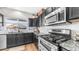 Kitchen boasts gray cabinets, granite countertops, stainless steel appliances, and a view of the backyard at 7931 W Harmony Ln, Peoria, AZ 85382