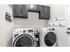Functional laundry room features washer, dryer, and storage cabinets at 7931 W Harmony Ln, Peoria, AZ 85382