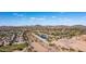 Aerial view of a community highlighting scenic trails, a lake, and the backdrop of picturesque mountains at 7931 W Harmony Ln, Peoria, AZ 85382
