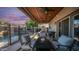 Comfortable outdoor seating area with fire table, ceiling fans, covered patio, and view of the pool at 7931 W Harmony Ln, Peoria, AZ 85382