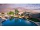 Backyard pool view with rock waterfall, seating, and privacy fence at 7931 W Harmony Ln, Peoria, AZ 85382