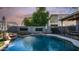 Backyard view of pool with rock waterfall feature, patio furniture, and privacy fence at 7931 W Harmony Ln, Peoria, AZ 85382