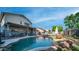 View of the pool with lush green lawn, rock waterfall, outdoor seating and patio at 7931 W Harmony Ln, Peoria, AZ 85382