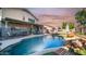 Inviting backyard pool with rock features, a safety fence, patio, and lovely landscaping at 7931 W Harmony Ln, Peoria, AZ 85382