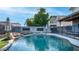 Backyard view of pool with rock waterfall feature, patio furniture, and privacy fence at 7931 W Harmony Ln, Peoria, AZ 85382