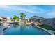 Inviting backyard pool with rock features, artificial turf, and lounge chairs under a blue sky at 7931 W Harmony Ln, Peoria, AZ 85382