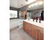 Bathroom boasting a tile floor, window, and vanity with light wood cabinets at 8341 W Gross Ave, Tolleson, AZ 85353
