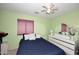 Bedroom with light green walls, white ceiling fan, double bed and dresser at 8341 W Gross Ave, Tolleson, AZ 85353