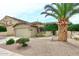Single story home boasts a two-car garage, desert landscaping, and mature palm tree at 8341 W Gross Ave, Tolleson, AZ 85353
