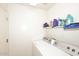 Bright laundry room featuring modern washer and dryer with convenient shelving at 8341 W Gross Ave, Tolleson, AZ 85353