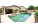 Backyard pool area with desert landscaping and tiled patio, perfect for outdoor relaxation and entertainment at 8341 W Gross Ave, Tolleson, AZ 85353