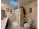 Bright bathroom with a vanity, a toilet, and a shower with a striped curtain under a skylight at 9060 N 47Th Ln, Glendale, AZ 85302