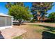 Rear view of the home with mature trees and a patio at 9863 W Country Club Ct, Sun City, AZ 85373