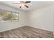 Bedroom features a ceiling fan and wood-look floors at 9863 W Country Club Ct, Sun City, AZ 85373