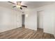 Bright bedroom featuring wood-look floors, neutral walls, and a ceiling fan at 9863 W Country Club Ct, Sun City, AZ 85373