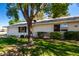 Attractive single-story home with tidy landscaping and mature shade trees on a sunny day at 9863 W Country Club Ct, Sun City, AZ 85373