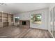 Spacious living room with a tiled fireplace, built-in shelving, and lots of natural light at 9863 W Country Club Ct, Sun City, AZ 85373