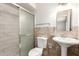 Updated bathroom with a tiled walk-in shower and modern pedestal sink at 9920 N 73Rd Ave, Peoria, AZ 85345