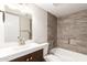 Bathroom featuring tiled shower and tile accent wall, vanity, and toilet at 9920 N 73Rd Ave, Peoria, AZ 85345