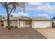 Inviting front exterior featuring a desert landscape, complemented by a two-car garage at 9920 N 73Rd Ave, Peoria, AZ 85345