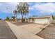 Street view of a single-story home with a two-car garage and desert landscaping at 9920 N 73Rd Ave, Peoria, AZ 85345