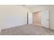 Spacious bedroom with neutral carpet, a door and an entrance to another room at 10837 W Bloch Rd, Tolleson, AZ 85353