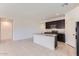 Open kitchen with a large island, stainless steel appliances, and dark cabinetry at 10837 W Bloch Rd, Tolleson, AZ 85353