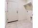 This laundry room features tiled floors, shelving, washer-dryer hookups, and access to the garage at 10837 W Bloch Rd, Tolleson, AZ 85353