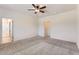 Expansive main bedroom with carpet, neutral walls, ceiling fan, and ensuite access at 10837 W Bloch Rd, Tolleson, AZ 85353