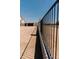Long shadow cast by a metal rod fence in a dry, unfinished backyard at 1228 N 106Th Pl, Mesa, AZ 85207