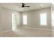 Bright bedroom with neutral walls, plush carpet, ceiling fan, and shuttered windows at 1228 N 106Th Pl, Mesa, AZ 85207