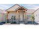 Inviting front porch with wood detailing, brick columns, and manicured landscaping at 1228 N 106Th Pl, Mesa, AZ 85207