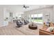 Modern living area with an open floor plan, light wood floors, stylish furniture, and backyard access at 1228 N 106Th Pl, Mesa, AZ 85207