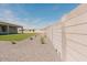 A view of the side yard showing the manicured artificial grass and the exterior block fence at 1229 N 106Th Pl, Mesa, AZ 85207