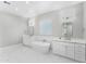 Bright bathroom featuring a stand alone tub and double sinks with marble countertops at 1229 N 106Th Pl, Mesa, AZ 85207