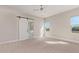 Spacious bedroom with plush carpeting and a barn door leading to the ensuite bathroom at 1229 N 106Th Pl, Mesa, AZ 85207