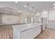 Bright, open kitchen featuring a large island with quartz countertops and modern light fixtures at 1229 N 106Th Pl, Mesa, AZ 85207