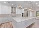 Open kitchen with a large island, ample storage, stainless steel hood, and modern light fixtures at 1229 N 106Th Pl, Mesa, AZ 85207