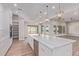 Bright, open kitchen featuring a large island with quartz countertops and modern light fixtures at 1229 N 106Th Pl, Mesa, AZ 85207