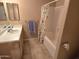 Bathroom with a single vanity, large mirror, a bathtub, and a shower with a floral shower curtain at 1264 W 6Th Ave, Apache Junction, AZ 85120