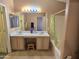 Bathroom with double vanity, large mirror, bathtub, and a shower with green shower curtain at 1264 W 6Th Ave, Apache Junction, AZ 85120