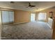 Spacious living room with plush carpet, ceiling fan, and sliding glass door at 1264 W 6Th Ave, Apache Junction, AZ 85120