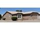 This home features a two-car garage, a neutral exterior color scheme, and desert landscaping at 1320 E Bellerive Dr, Chandler, AZ 85249