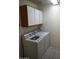 Functional laundry room equipped with a modern washer and dryer, paired with overhead storage for organization at 1320 E Bellerive Dr, Chandler, AZ 85249