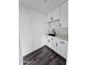 Functional laundry room with white cabinets, marble countertop, modern black faucet and hardwood floors at 1401 S Rita Ln, Tempe, AZ 85281