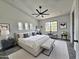 Spacious primary bedroom features modern decor, a ceiling fan, and abundant natural light from large windows at 1401 S Rita Ln, Tempe, AZ 85281