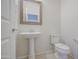 Bathroom with a pedestal sink, toilet, and wall mirror at 1624 N 77Th Gln, Phoenix, AZ 85035
