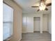 Bedroom with wood-look flooring, ceiling fan, closet with sliding doors, and a door at 1624 N 77Th Gln, Phoenix, AZ 85035